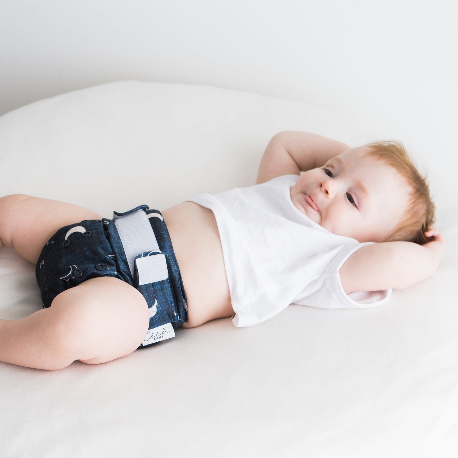 Baby boy wearing navy blue velcro reusable nappy