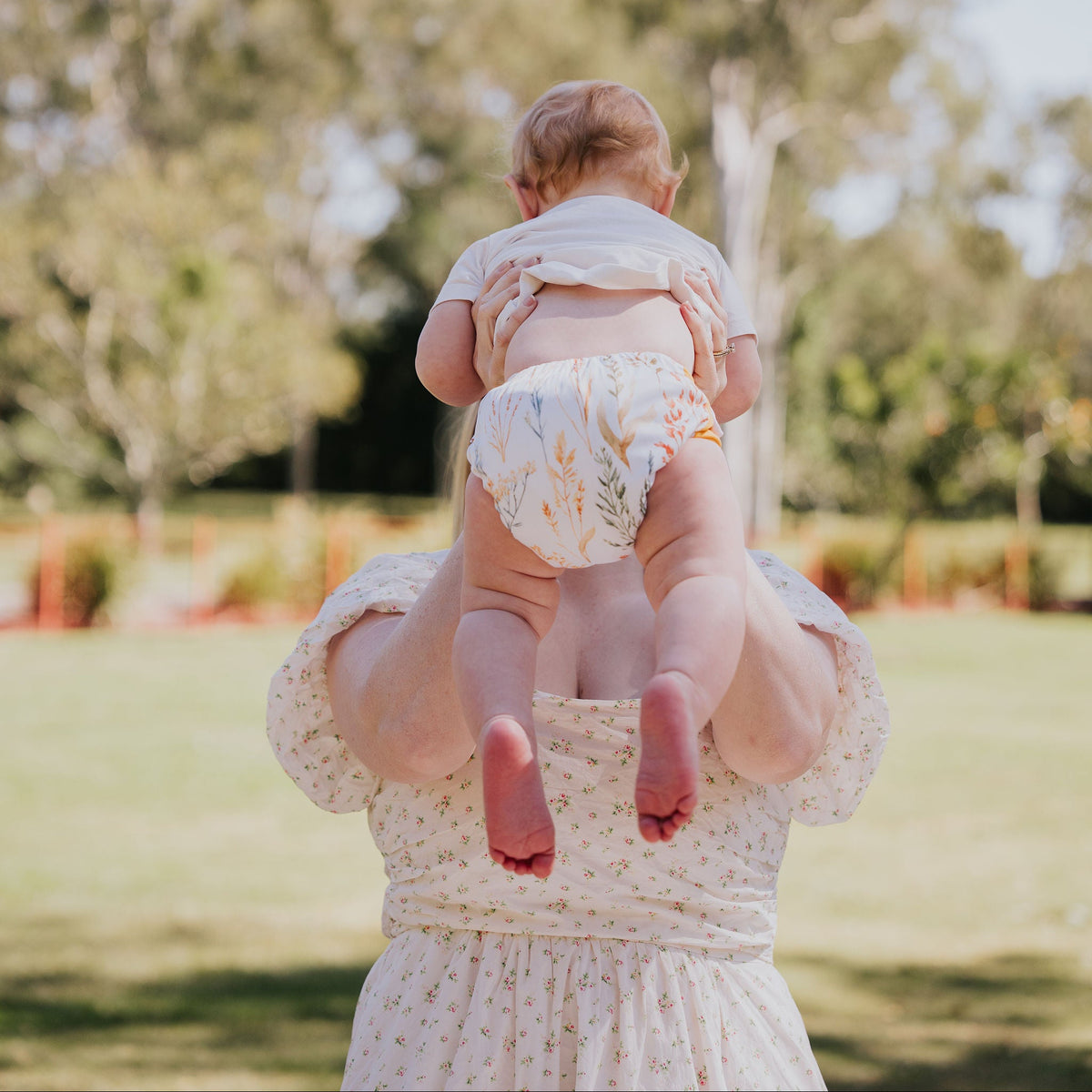 Parent lifting a toddler wearing a Gremlin pull up nappy in Wild Prairie print