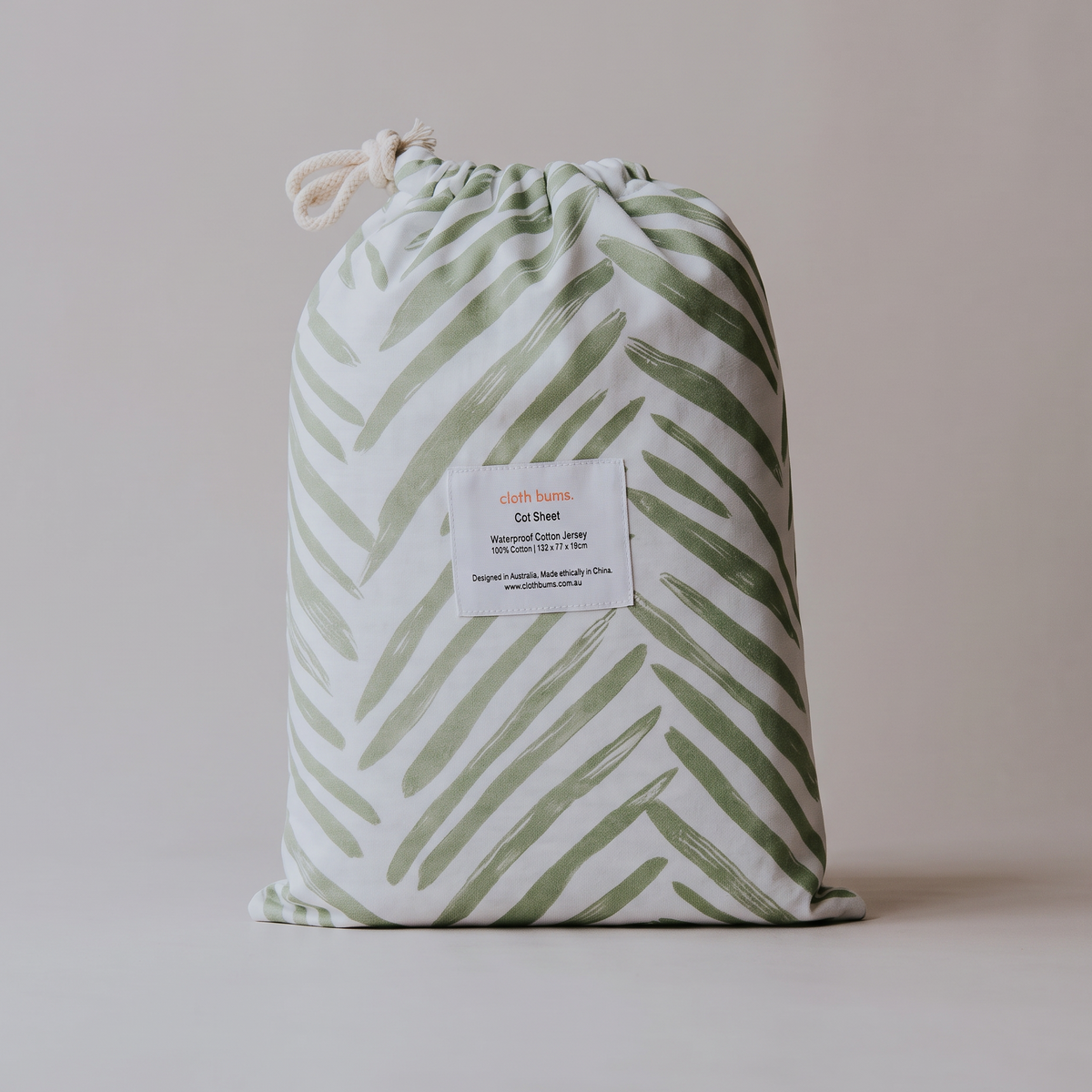 Waterproof cot sheet in Greenhouse print, packed in its drawstring bag