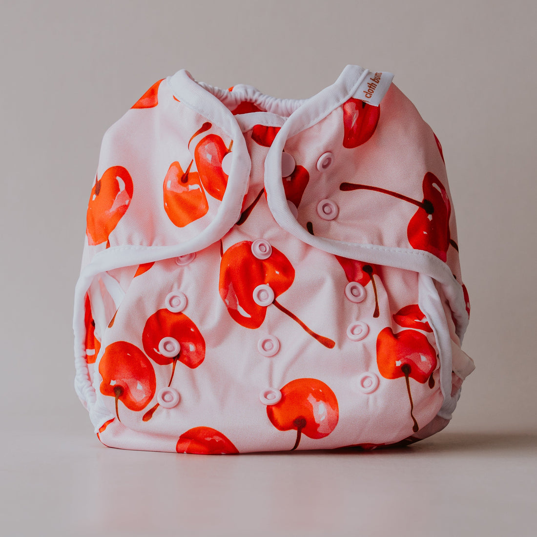 Baby diaper with red cherry pattern on a plain background