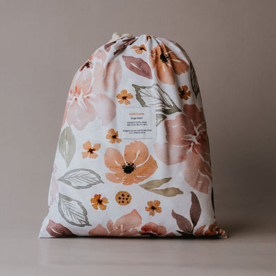 Cloth Bums Peony Pop waterproof fitted sheet on a bed