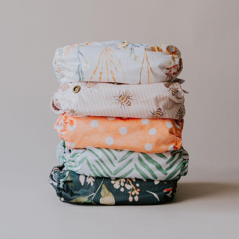 Stack of PIXIE one size cloth nappies in the five new prints by Cloth Bums