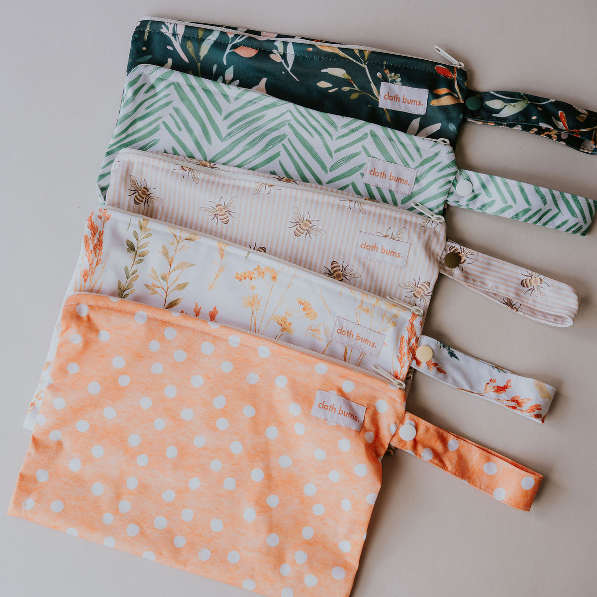 Small wet bags fanned out in the five new prints