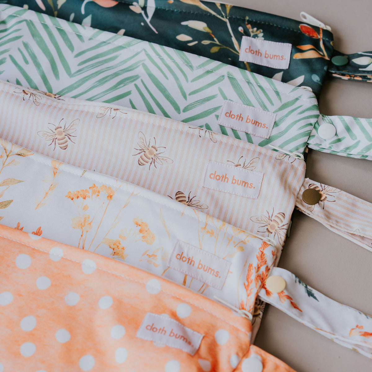 Close-up of small wet bags in the new prints, including the bee and dot prints