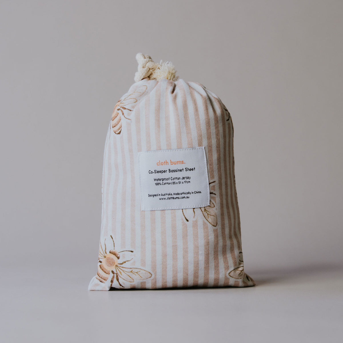 Co-sleeper waterproof sheet in Beeline print, packed in its drawstring bag
