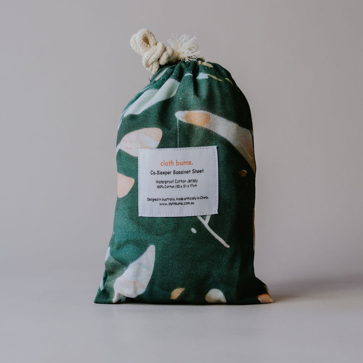 Co-sleeper waterproof sheet in Evergreen print, packed in its drawstring bag