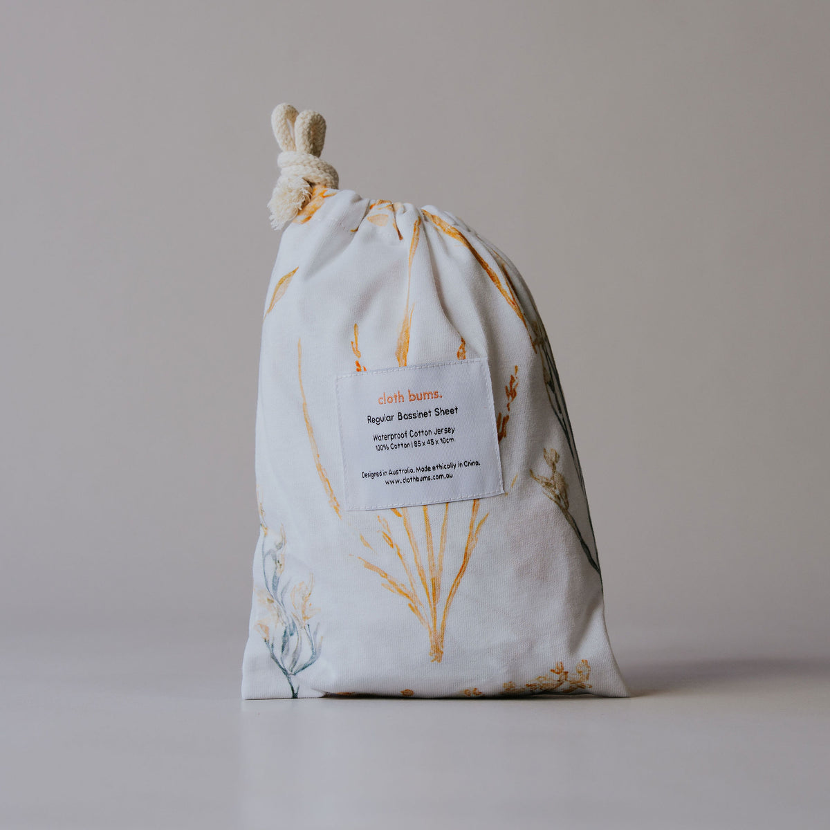 Regular bassinet waterproof sheet in Wild Prairie print, packed in its drawstring bag