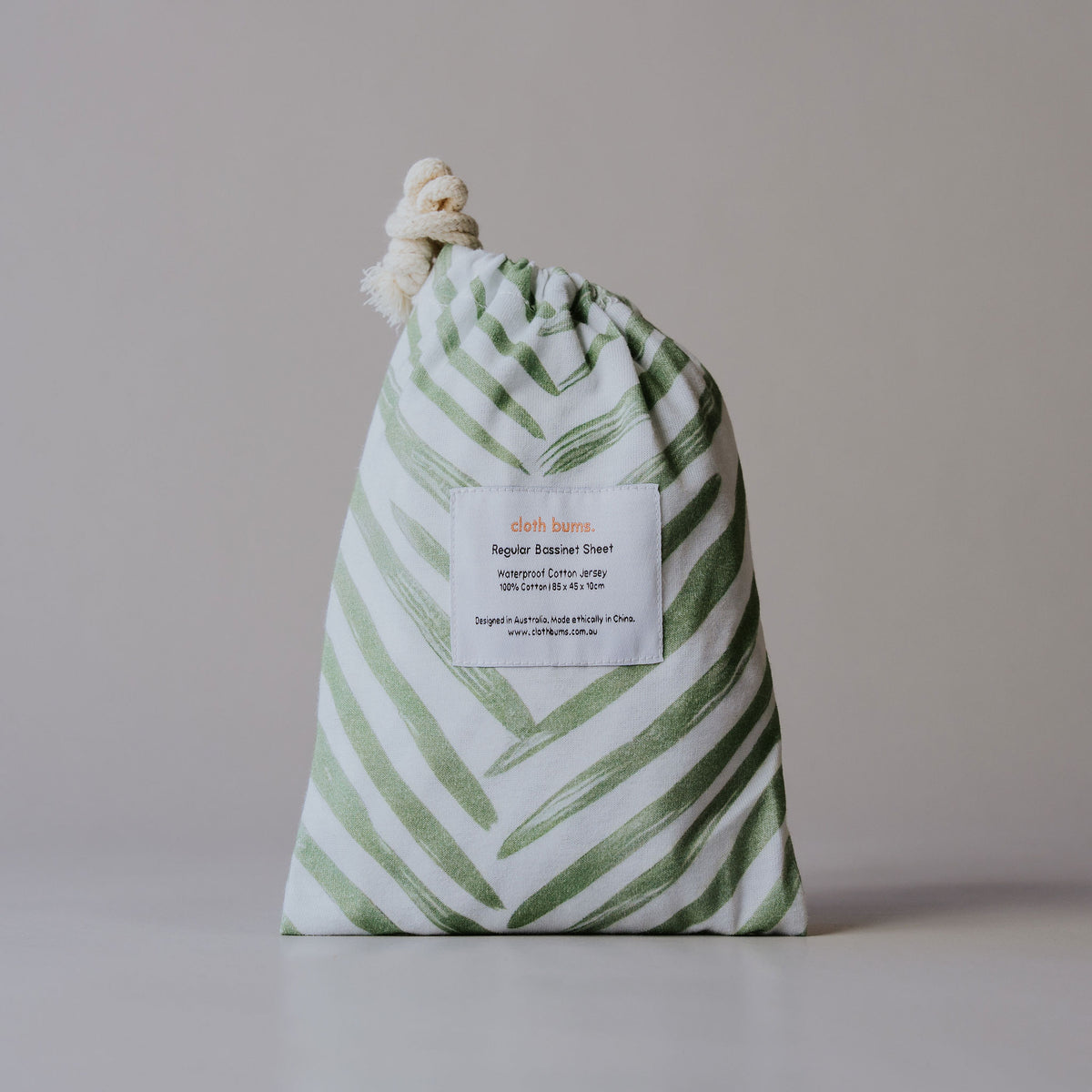 Regular bassinet waterproof sheet in Greenhouse print, packed in its drawstring bag