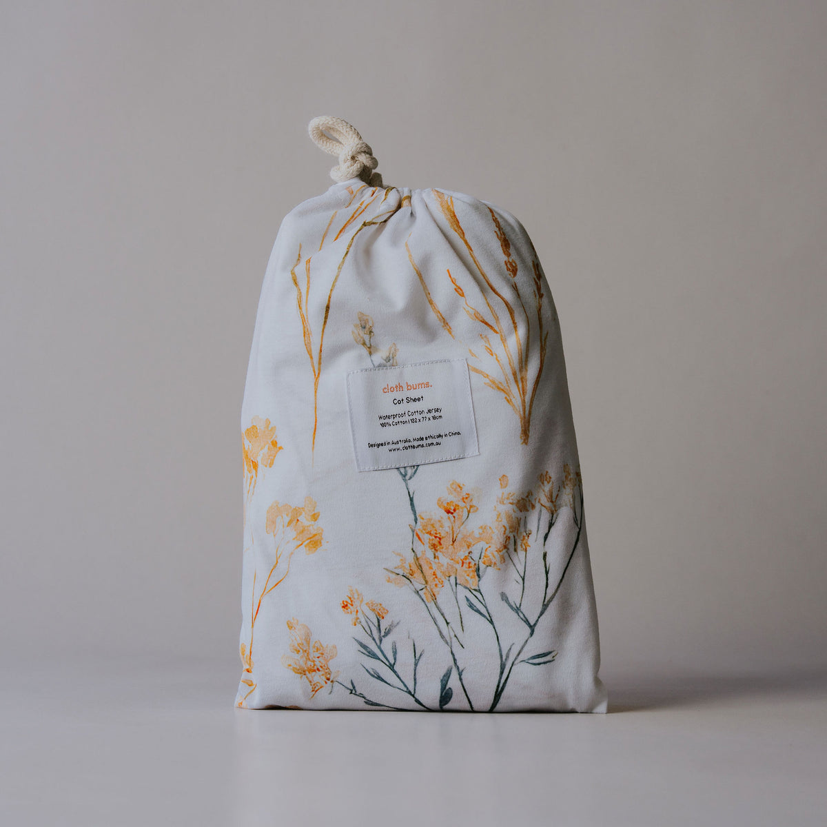 Waterproof cot sheet in Wild Prairie print, packed in its drawstring bag