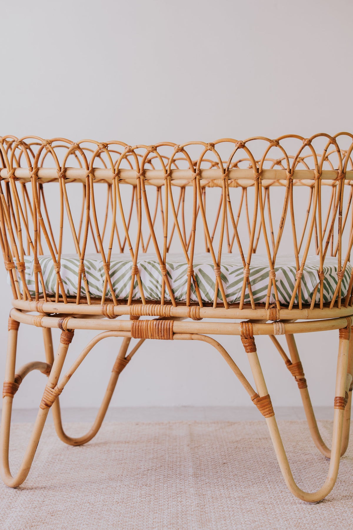Rattan bassinet made up with a Greenhouse waterproof sheet