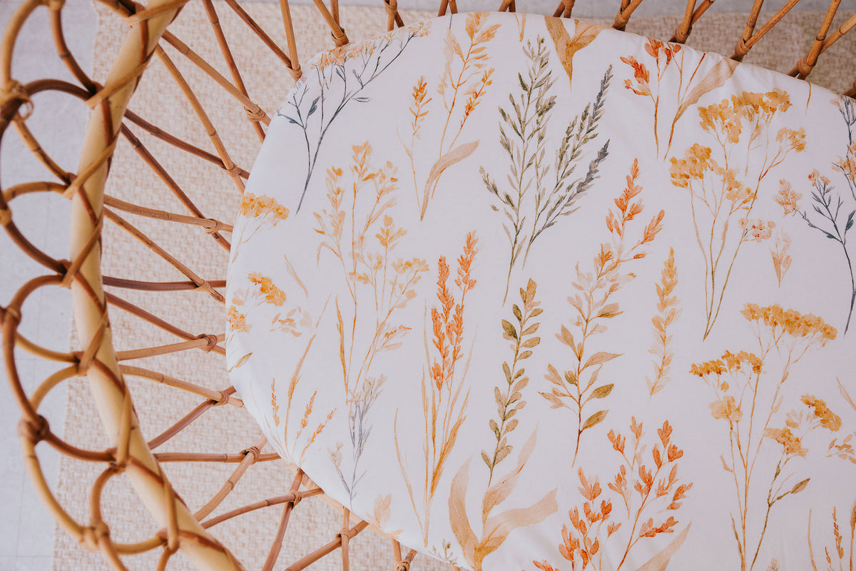 Close-up of the Wild Prairie waterproof sheet in a rattan bassinet