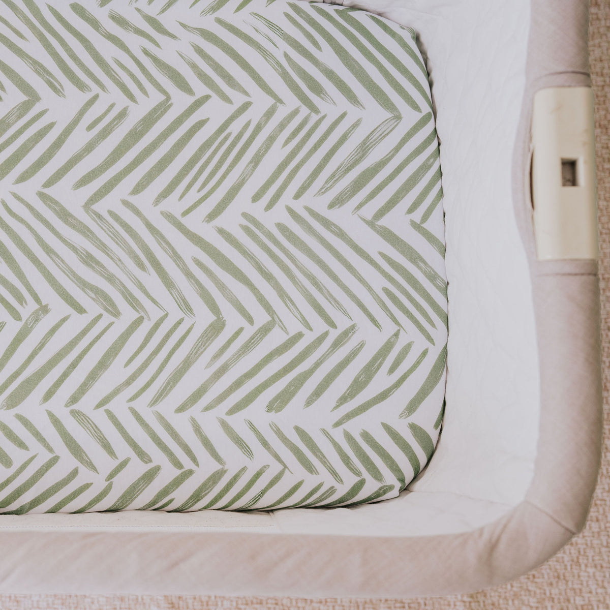 Close-up of the Greenhouse waterproof sheet fitted in a bedside co-sleeper