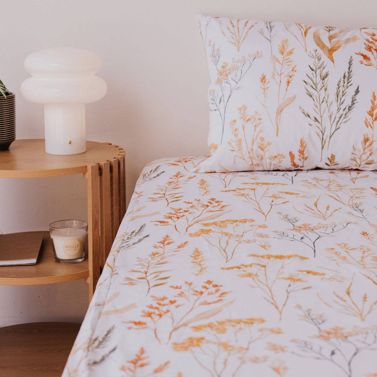 Wild Prairie waterproof fitted sheet and pillowcase on a bed beside a timber side table