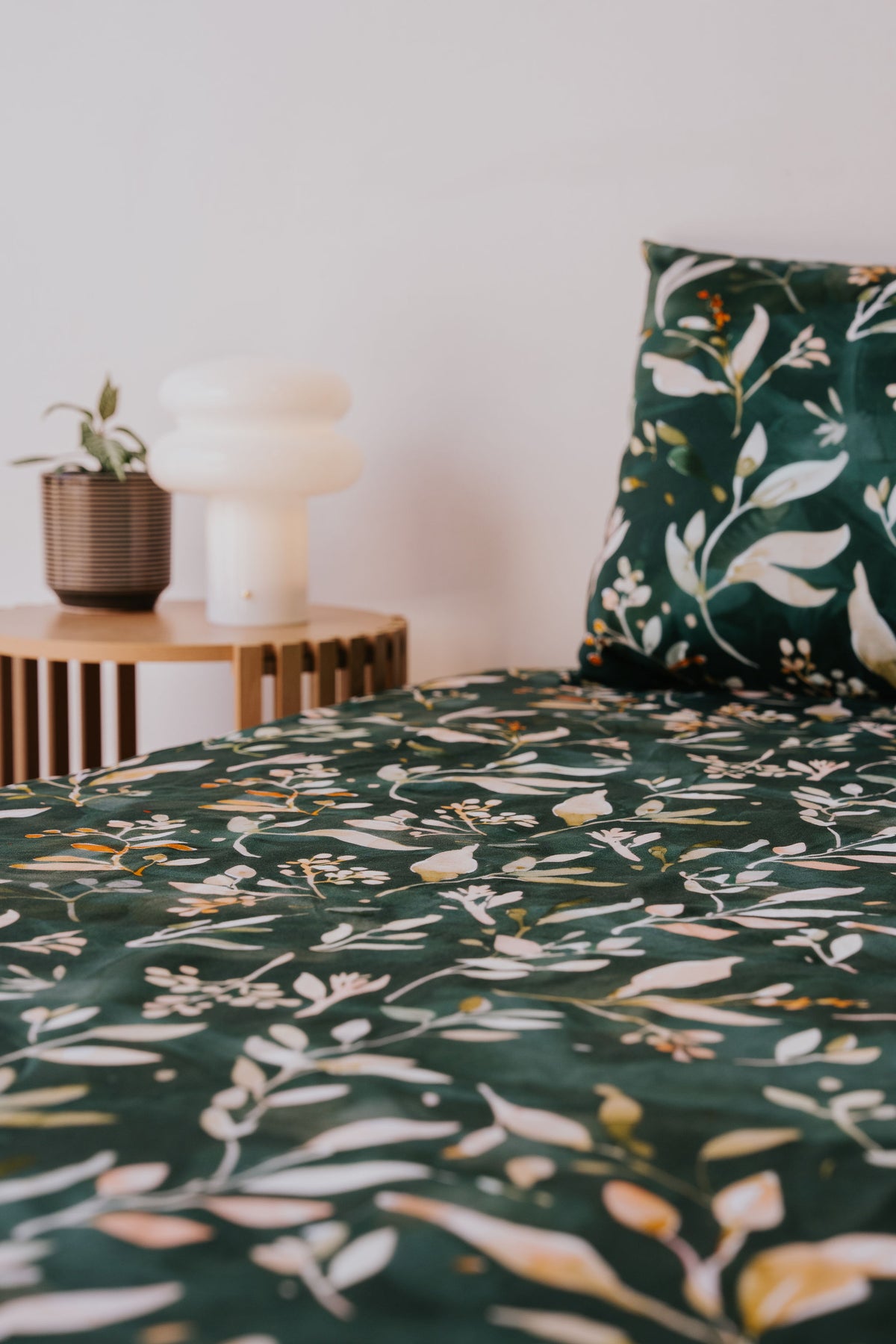 Evergreen waterproof fitted sheet and pillowcase on a bed, angled view