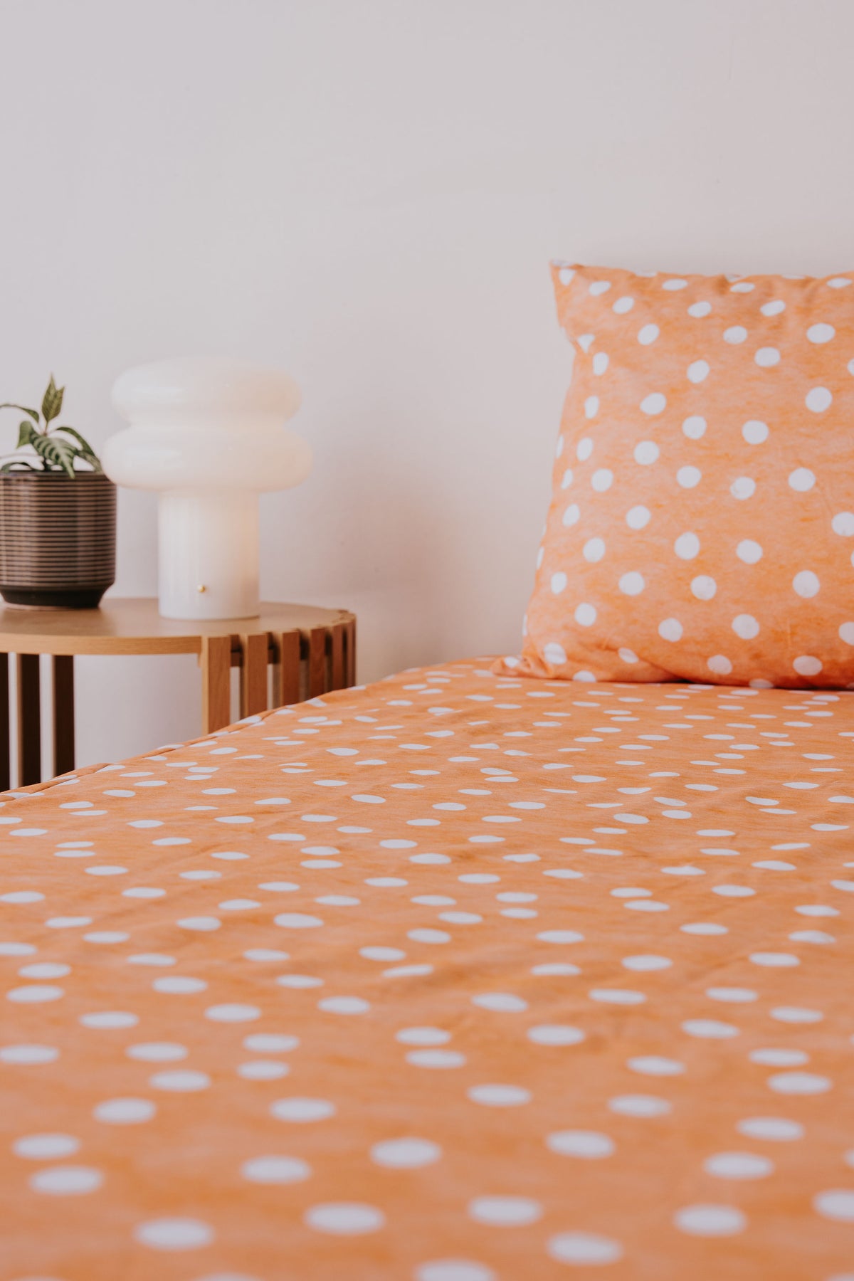 Marmalade waterproof fitted sheet and pillowcase on a bed, angled view