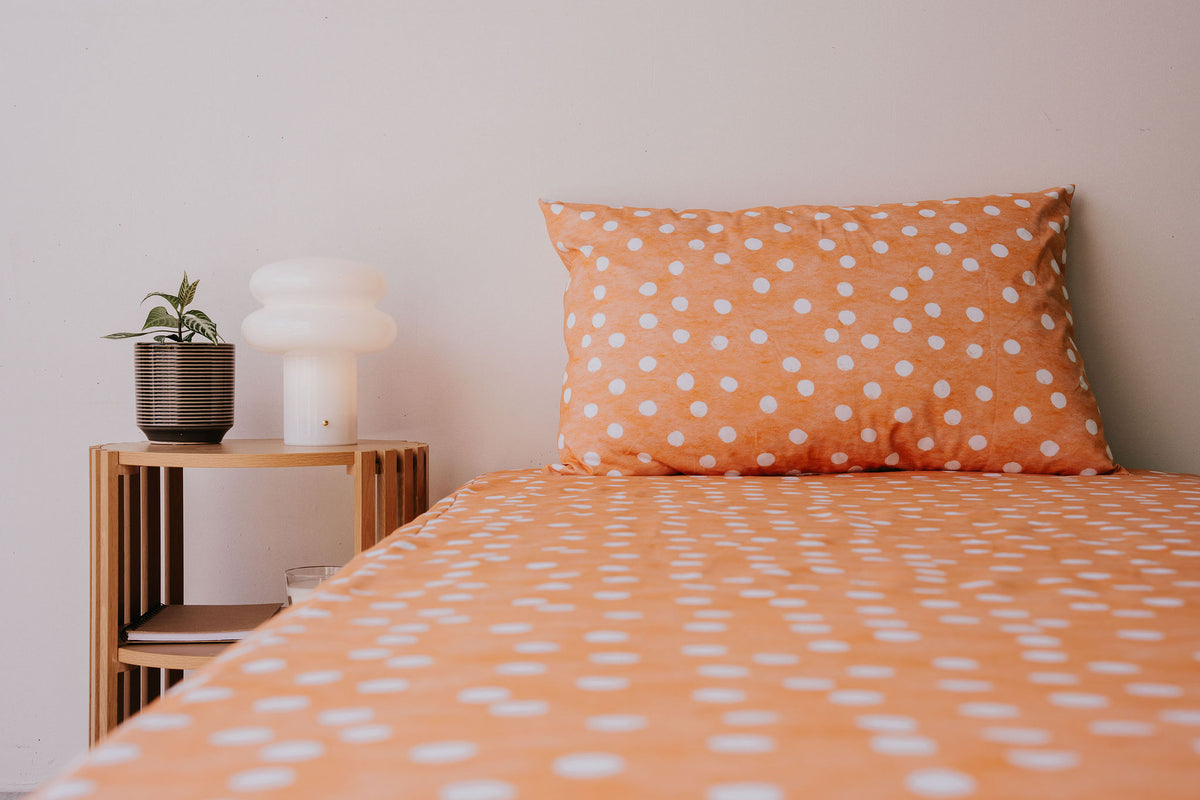 Close view of a bed made up in the Marmalade fitted sheet and pillowcase