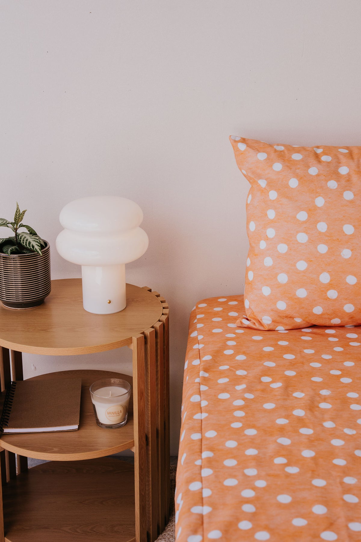 Marmalade waterproof fitted sheet and pillowcase on a bed beside a timber side table