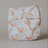 White cloth diaper with orange rainbow patterns on a beige background