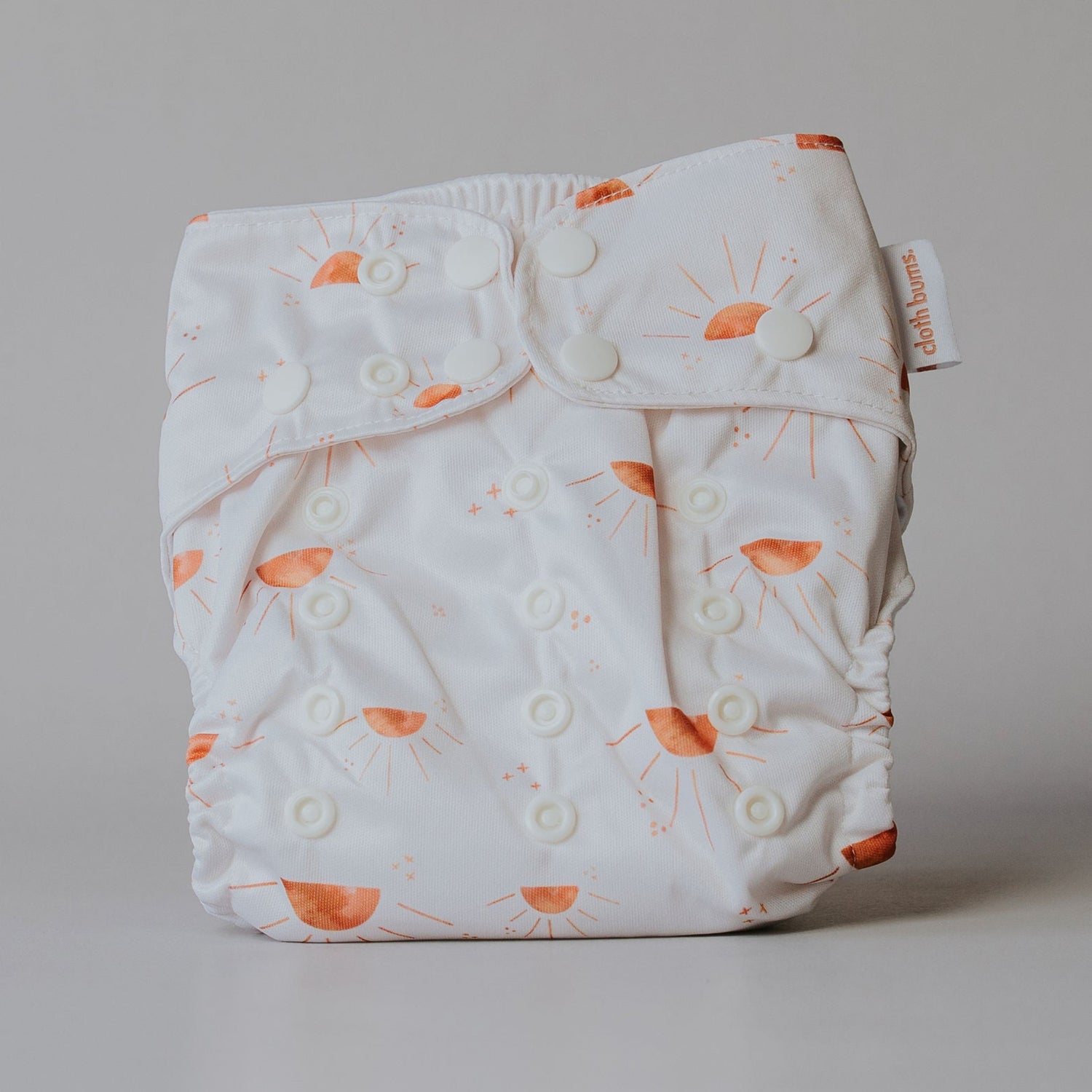 Sun patterned cloth diaper on a plain background