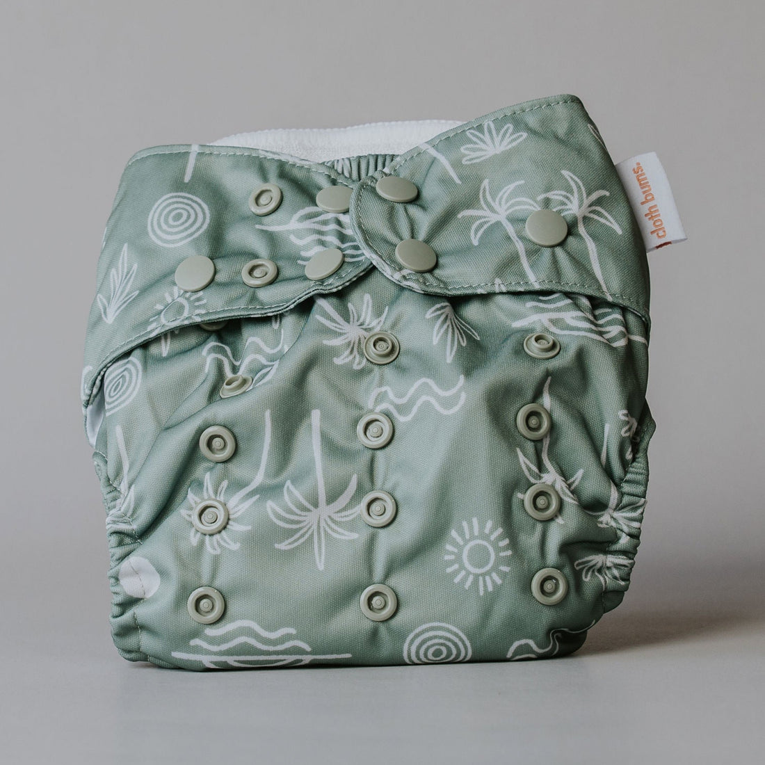 Green patterned cloth diaper on a gray background