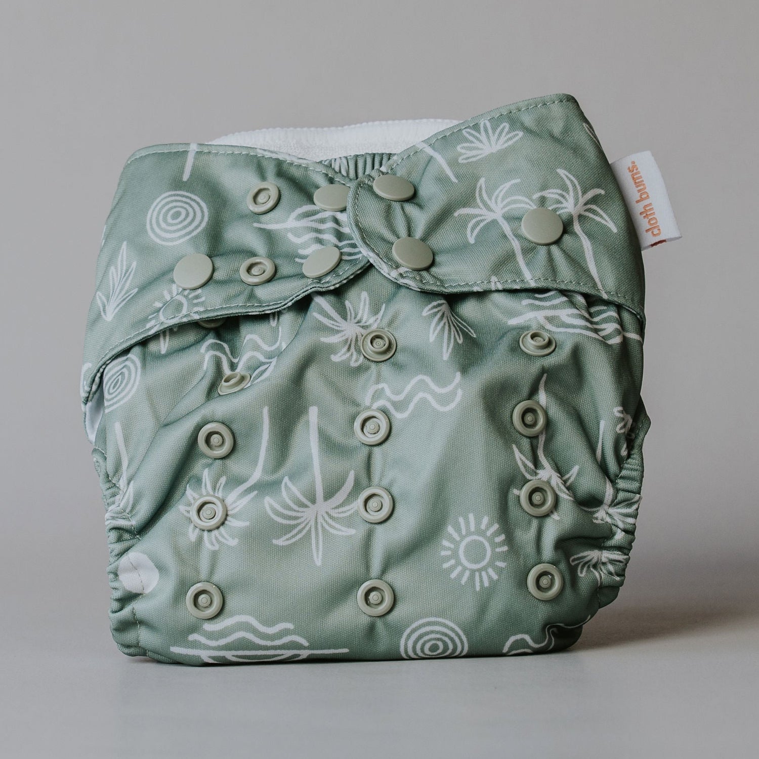 Green patterned cloth diaper on a gray background