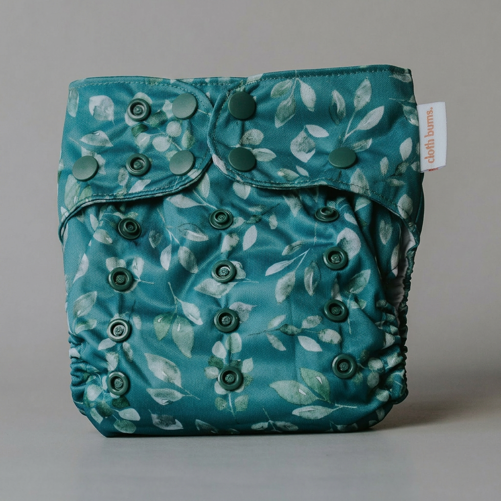 Teal cloth diaper with leaf pattern on a gray background