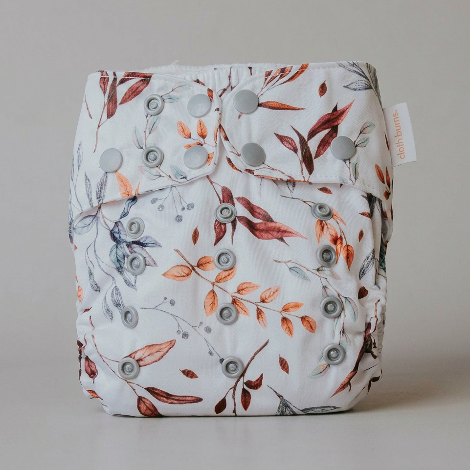 Floral-patterned diaper with button closures on a neutral background