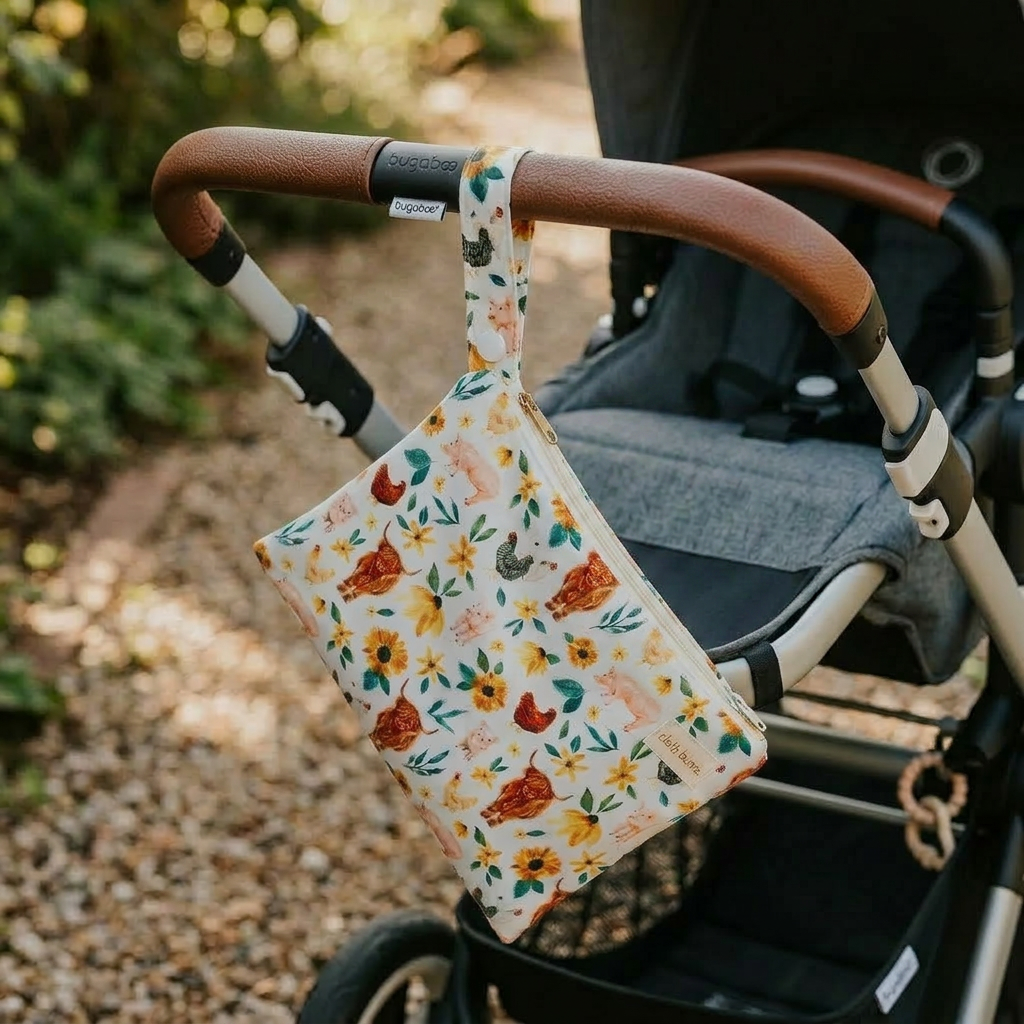 Floral-patterned bag hanging on a stroller handle with a blurred natural background