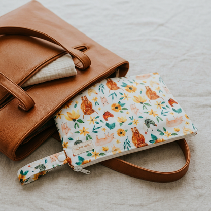 Brown leather handbag with a floral-patterned pouch on a textured surface